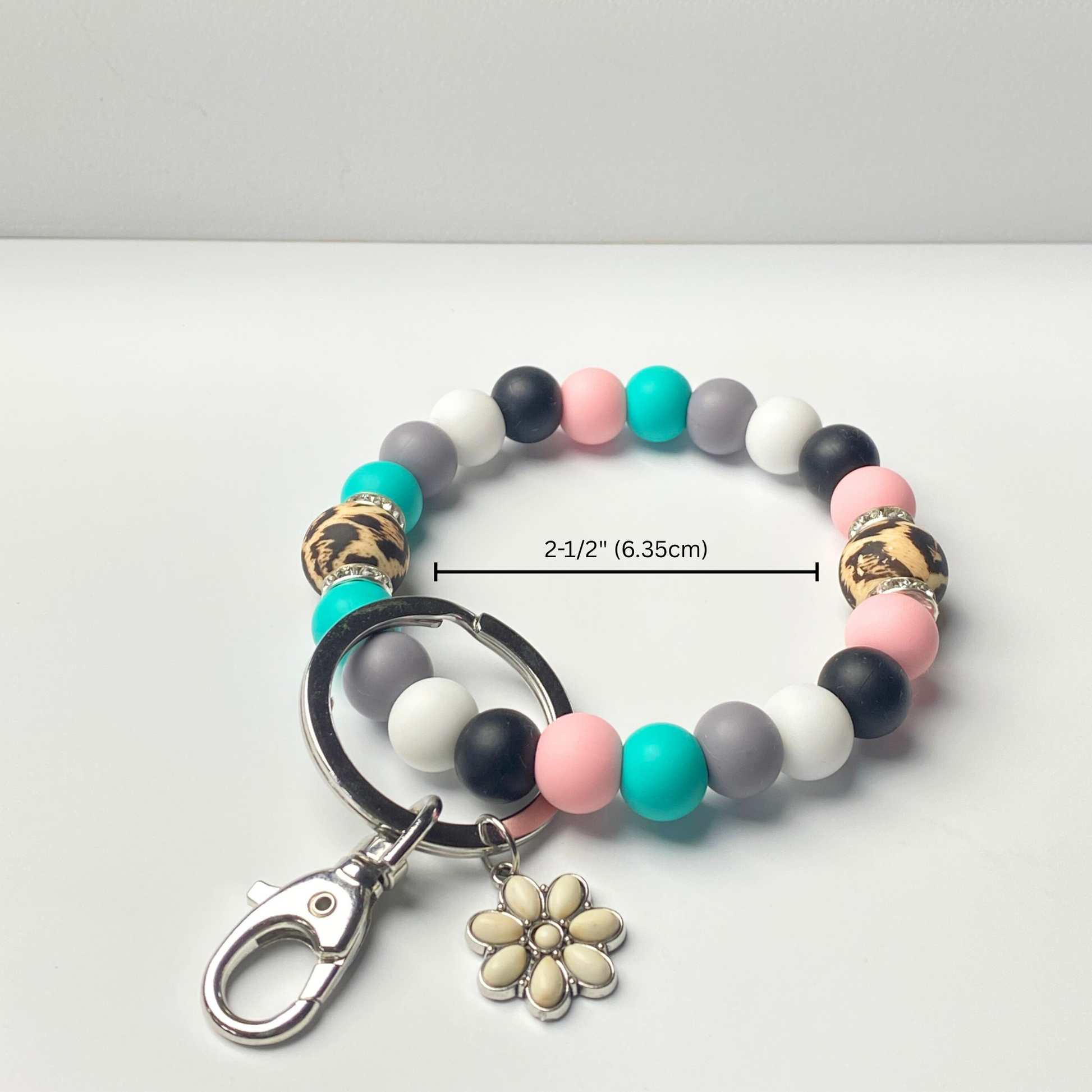 Multicolored beaded keychain with a flower charm on a white background