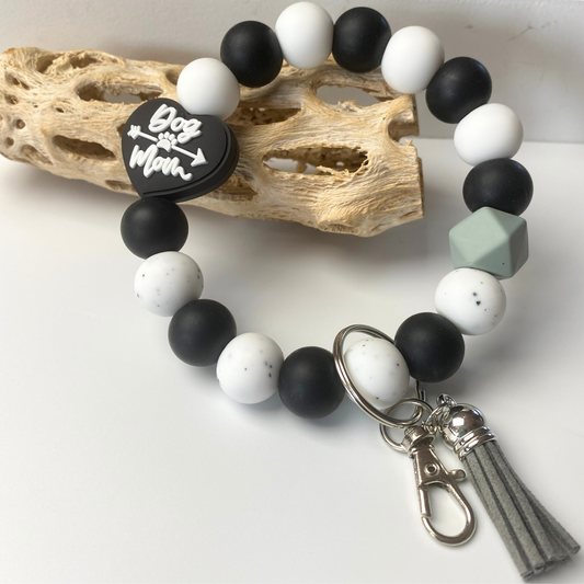 Beaded bracelet with heart-shaped 'Dog Mom' charm on a white background