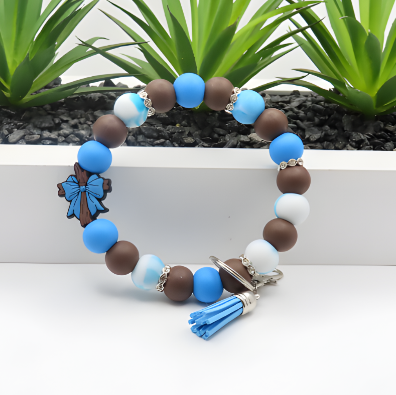 Beaded bracelet with blue, brown, and white beads on a white surface with green plants in the background