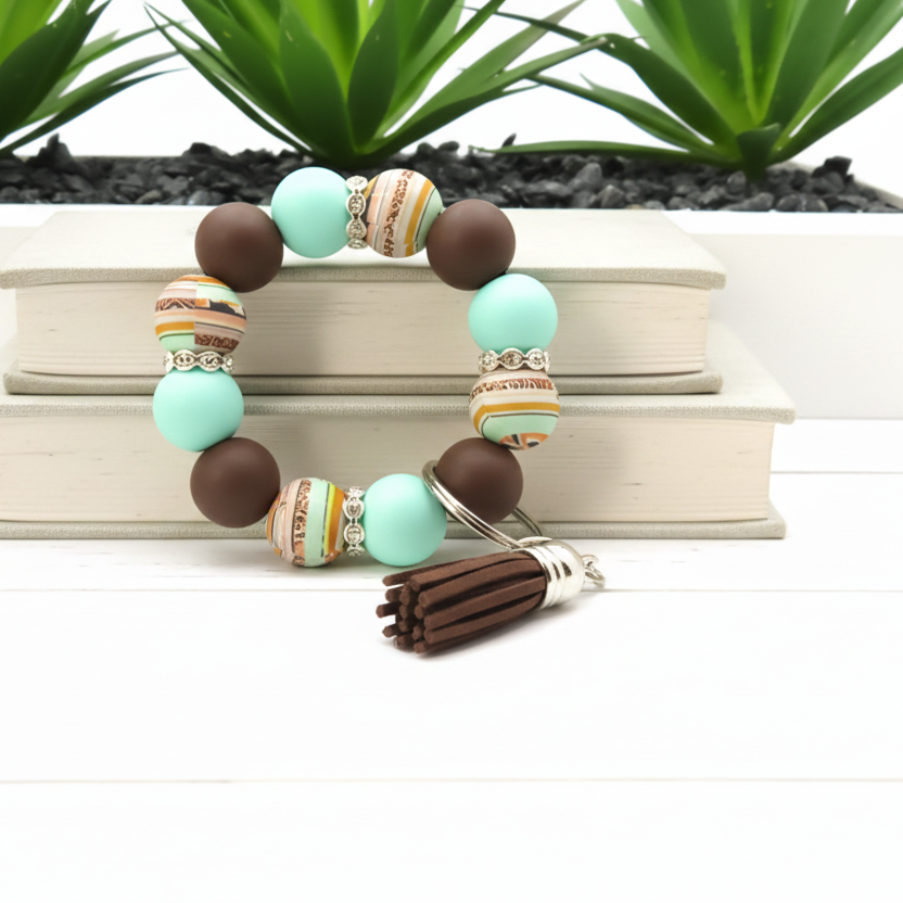 Beaded bracelet with tassel on a white background with plants in the background