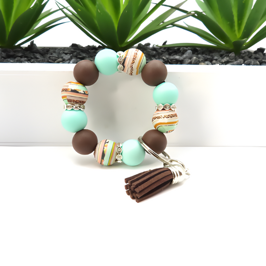 Beaded bracelet with tassel on a white background with plants in the background