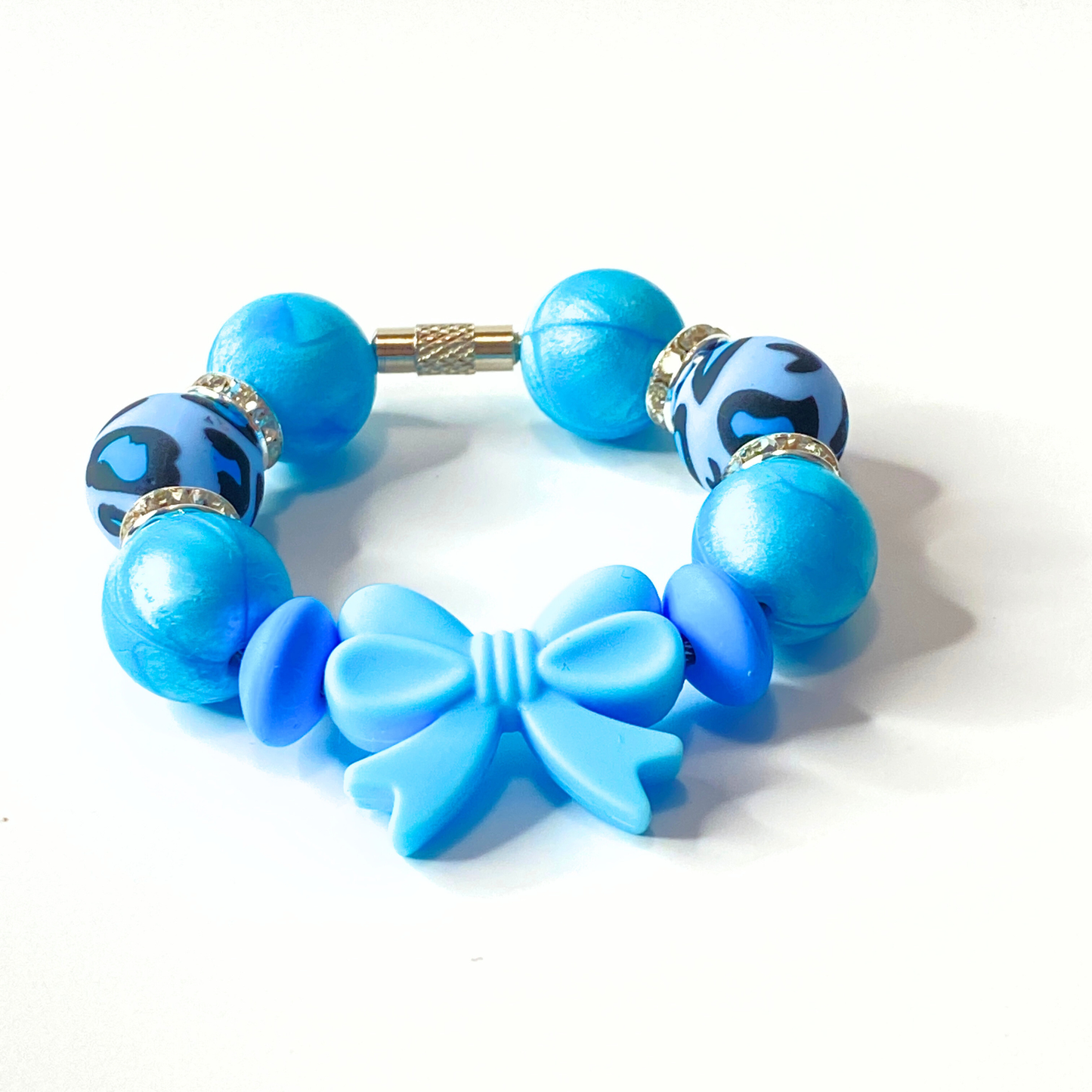 Blue beaded bracelet with a bow charm on a white background