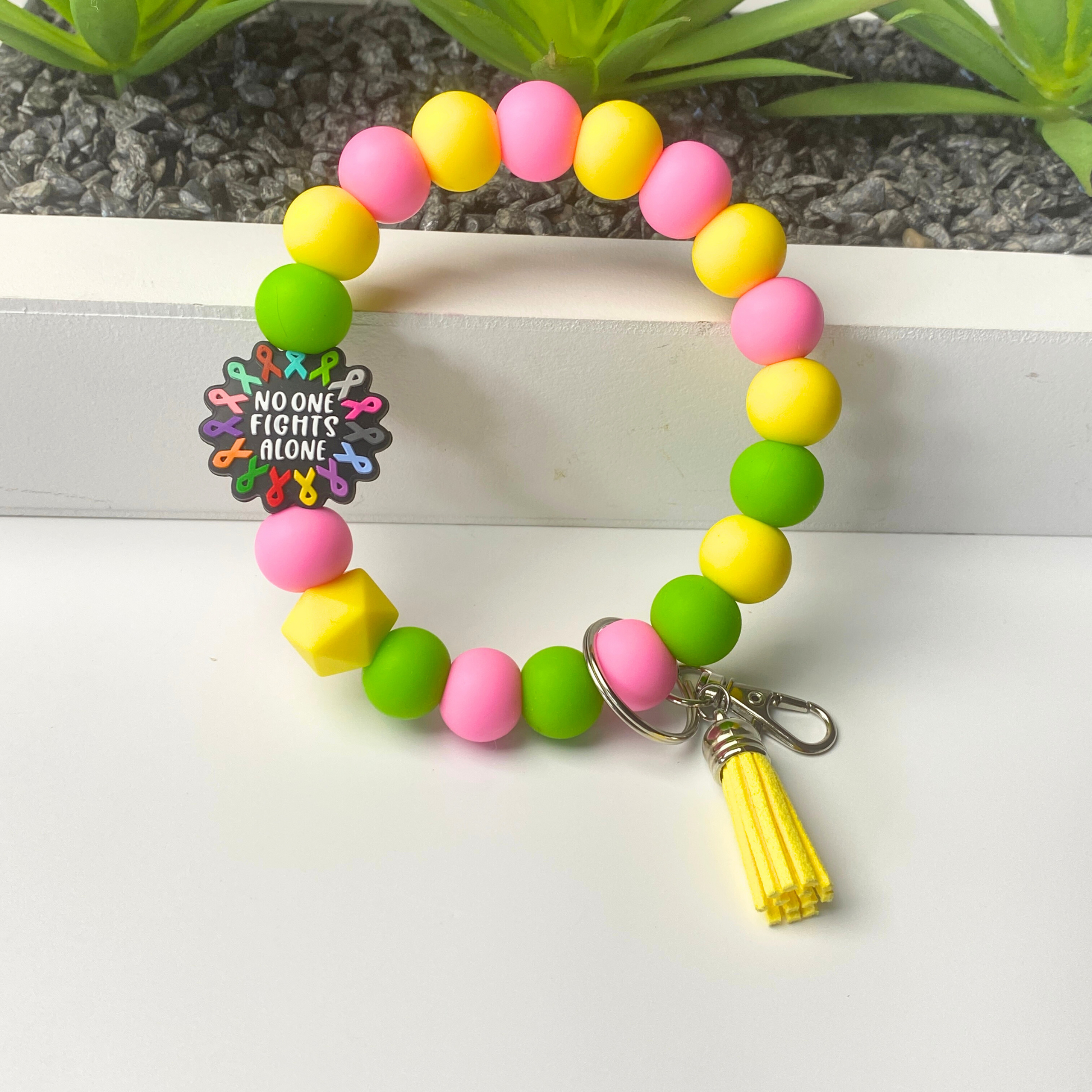 Colorful beaded bracelet with a keychain on a white surface