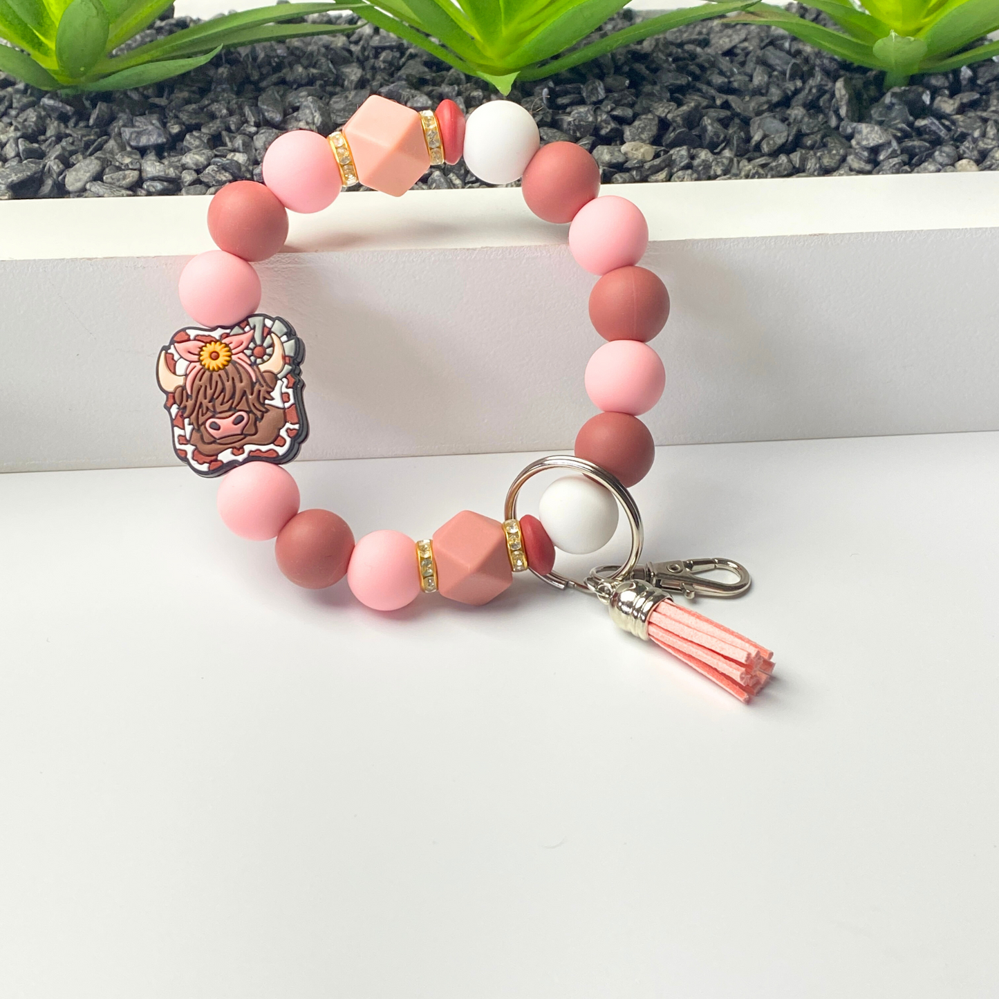 Beaded bracelet with a keychain and character charm on a white surface.