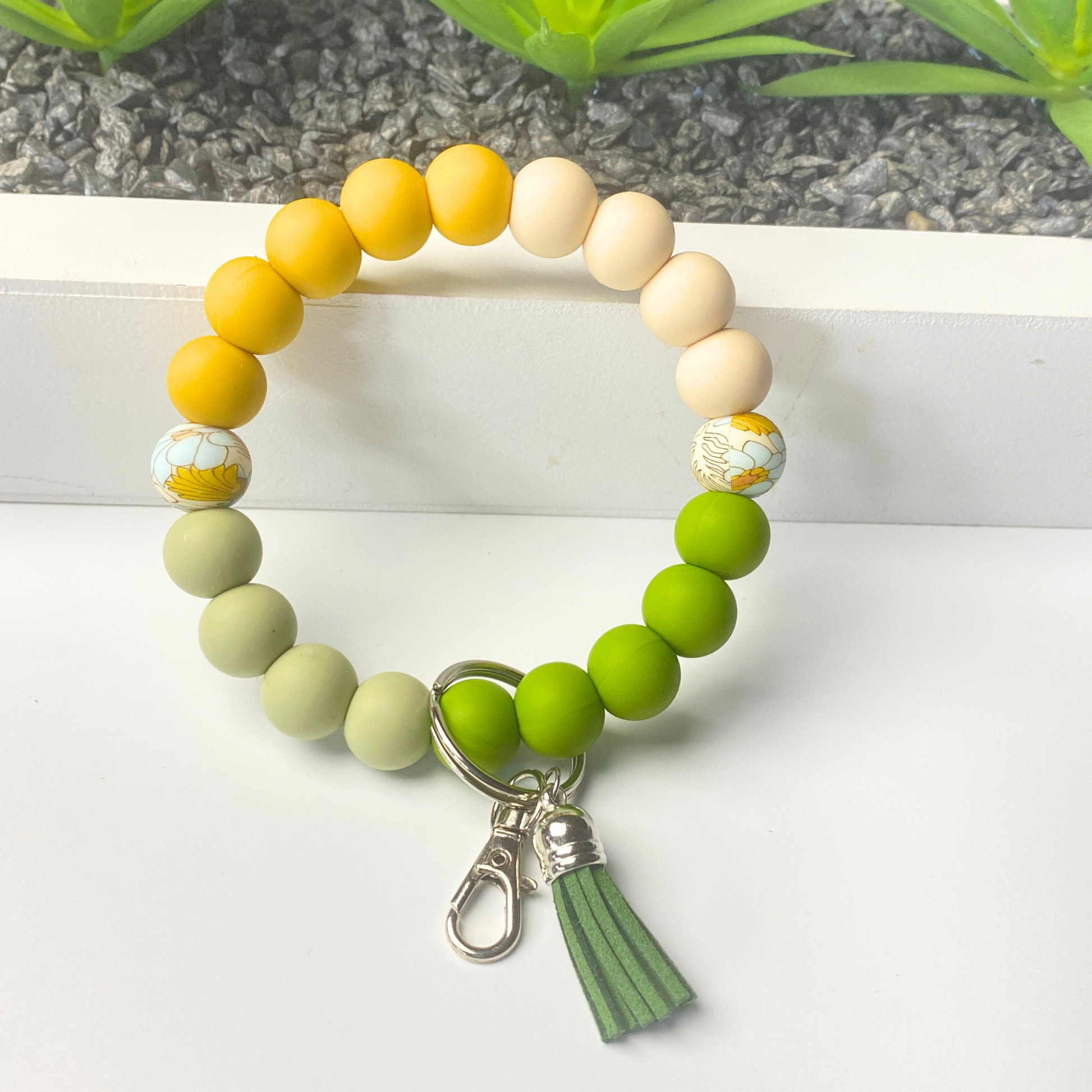 Beaded bracelet with a tassel charm on a white surface