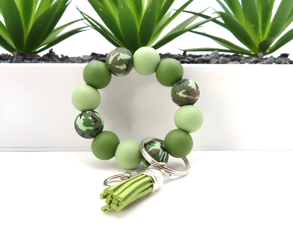 Green beaded bracelet with camouflage pattern and keychain on a white background