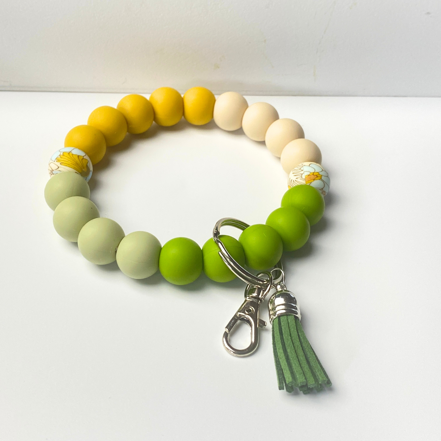 Colorful beaded bracelet with a tassel charm on a white background