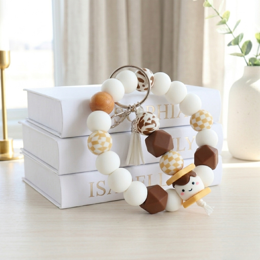 Decorative wreath with white, brown, and gold ornaments on a white surface with books in the background.