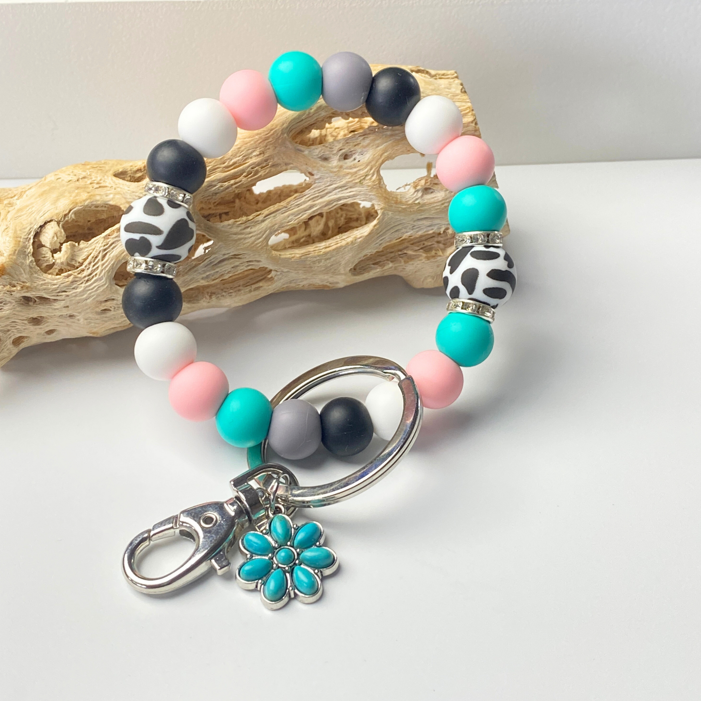 Multicolored beaded bracelet with a keychain on a white surface