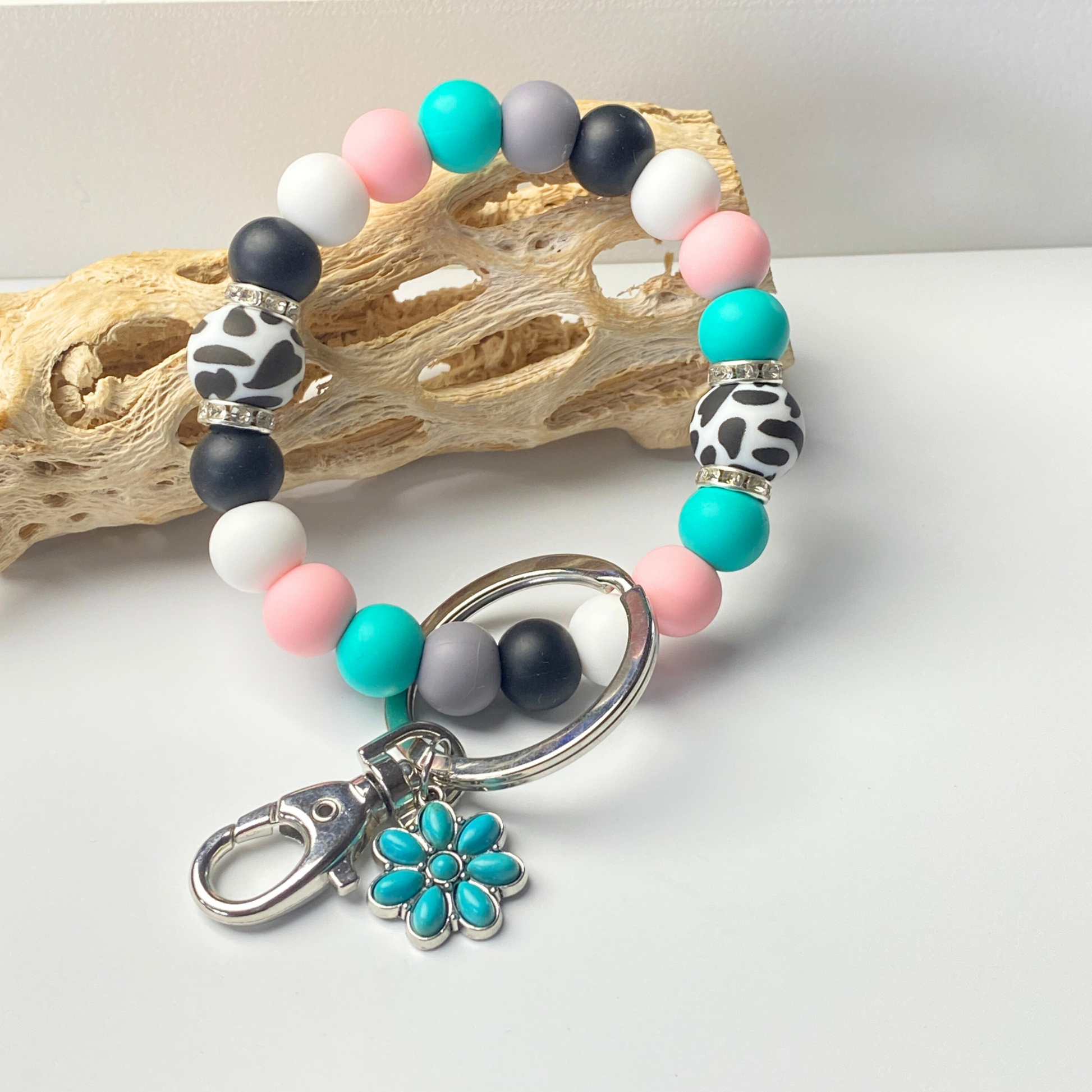 Multicolored beaded bracelet with a keychain on a white surface