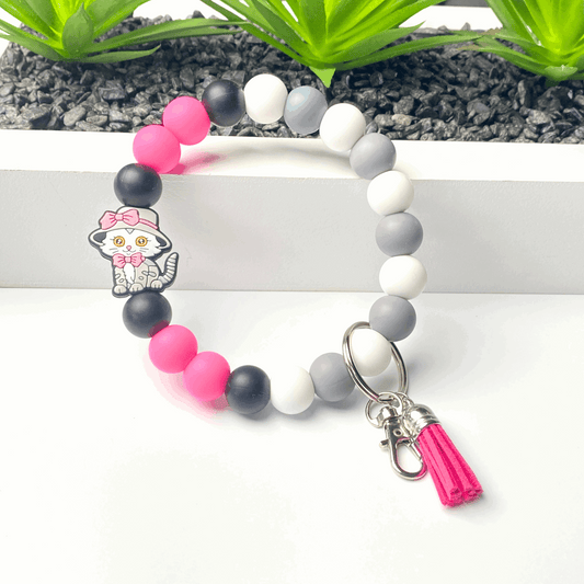 Colorful beaded bracelet with a character charm and tassel on a white background