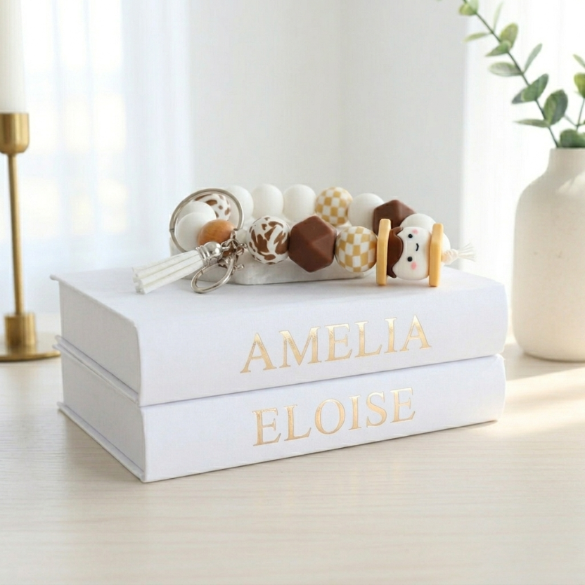 White box with 'Amelia Eloise' branding, containing baby toys on a light wooden surface.