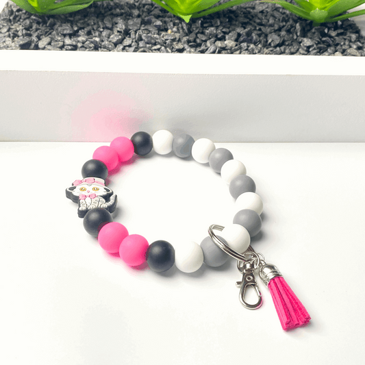 Beaded bracelet with colorful beads and a pink tassel on a white background