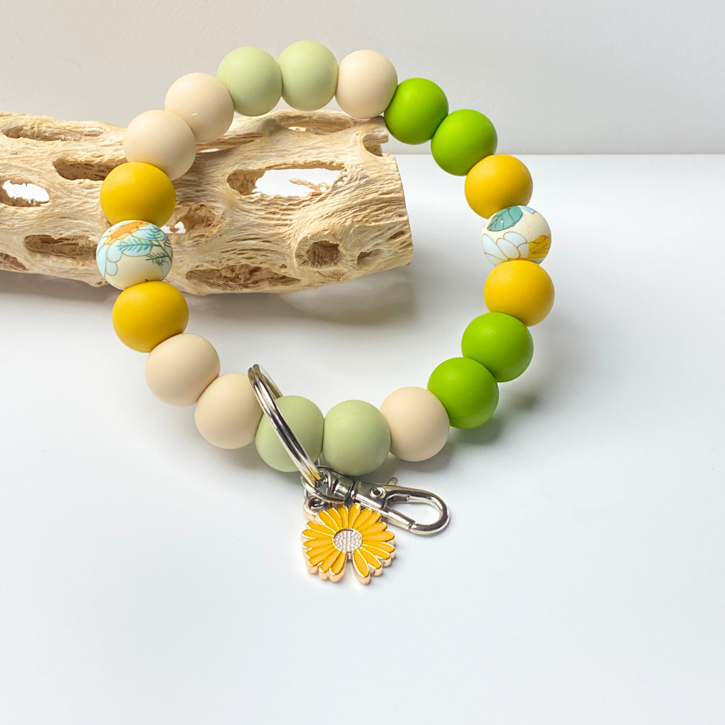 Colorful beaded bracelet with a sunflower charm on a light background