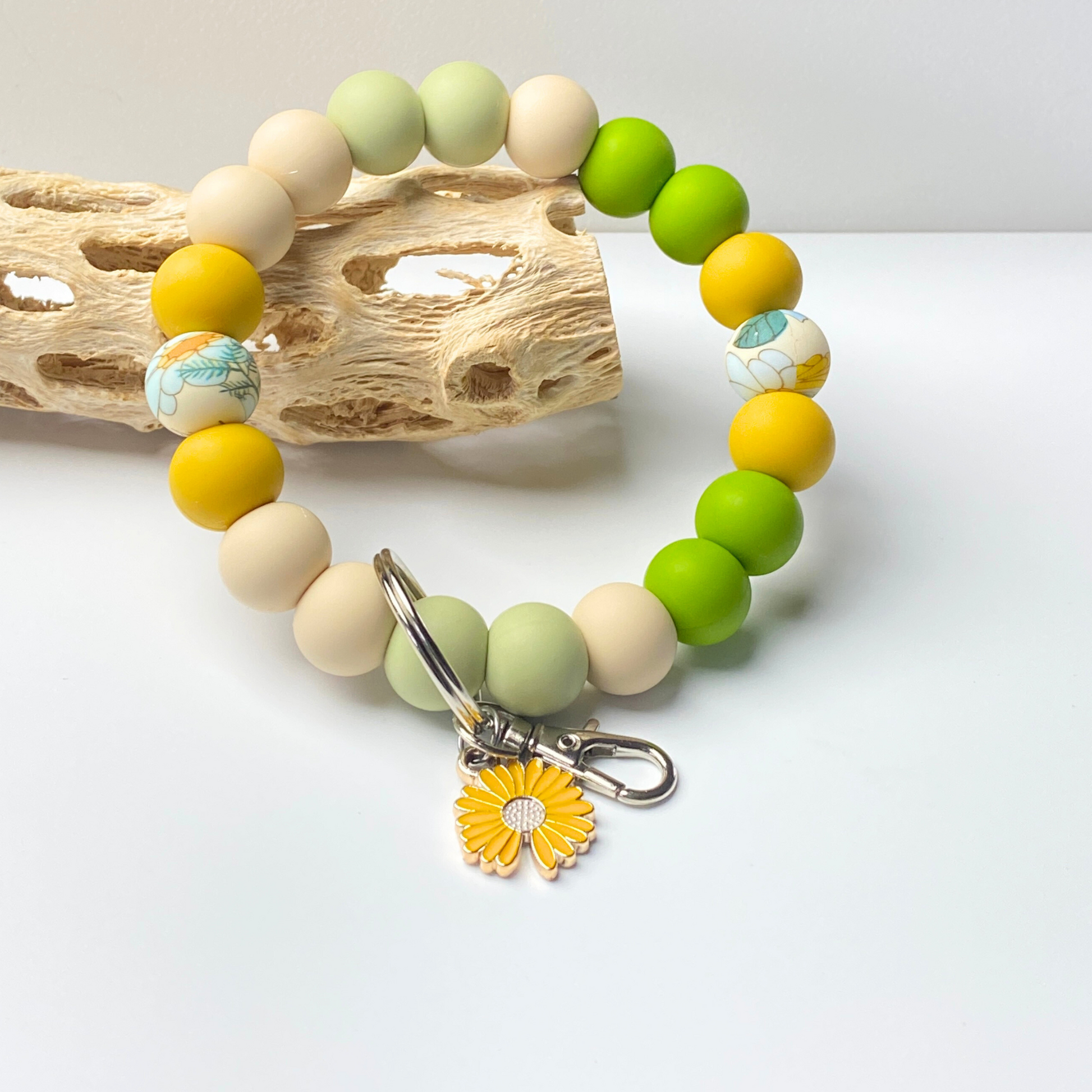 Colorful beaded bracelet with a sunflower charm on a light background