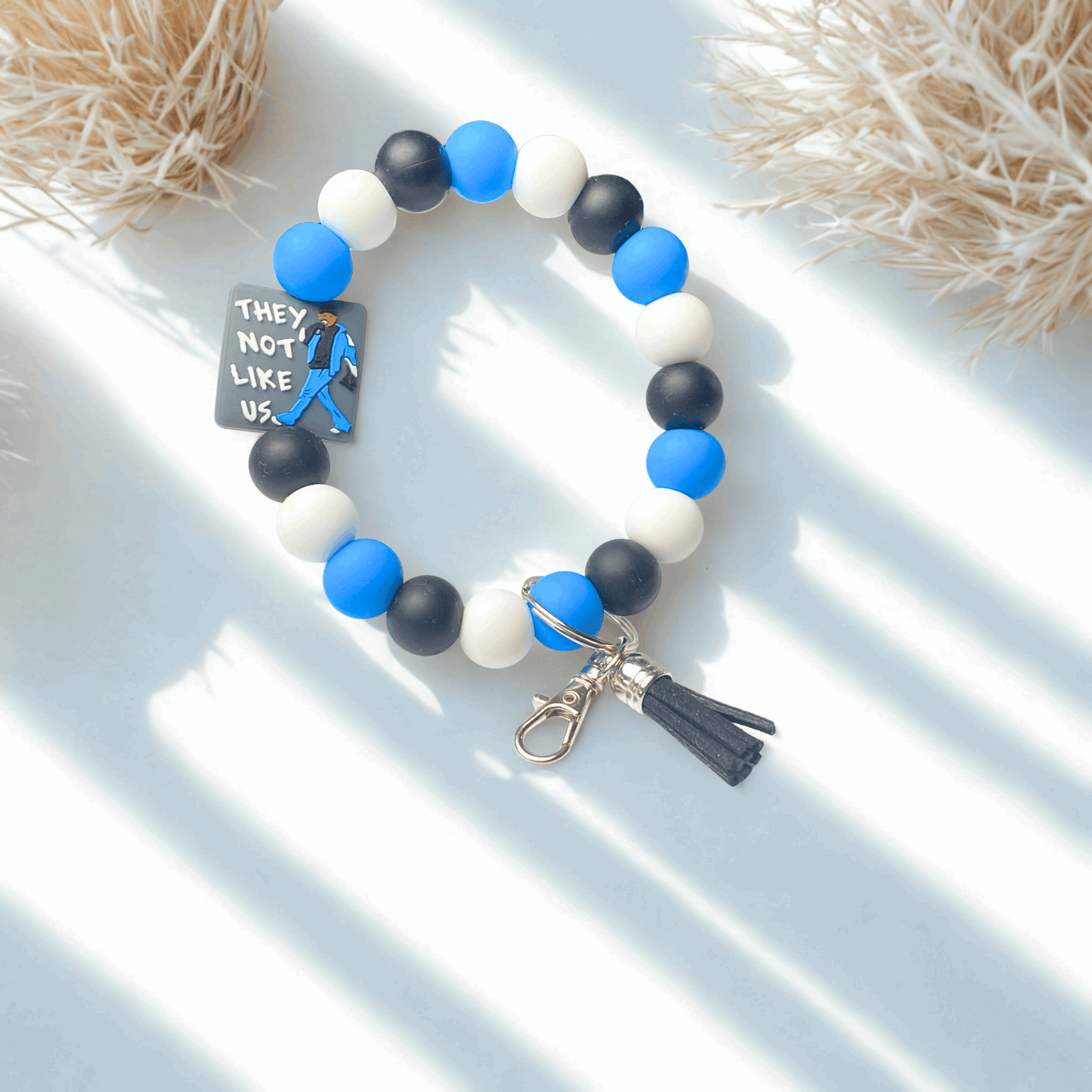 Beaded bracelet with blue, black, and white beads on a light background