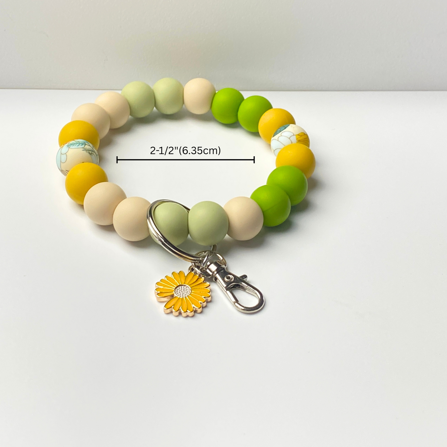 Beaded bracelet with a sunflower charm on a white background