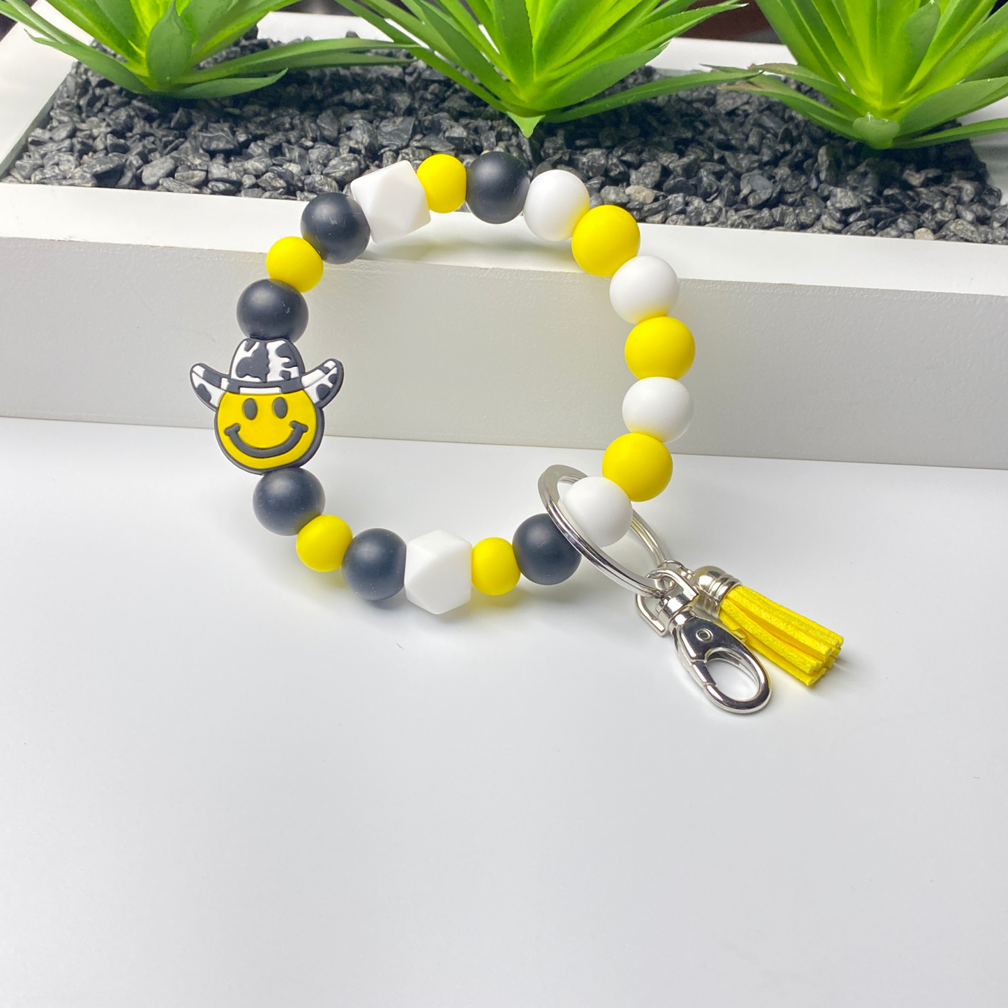 Bracelet with smiley face charm and tassel on a white background