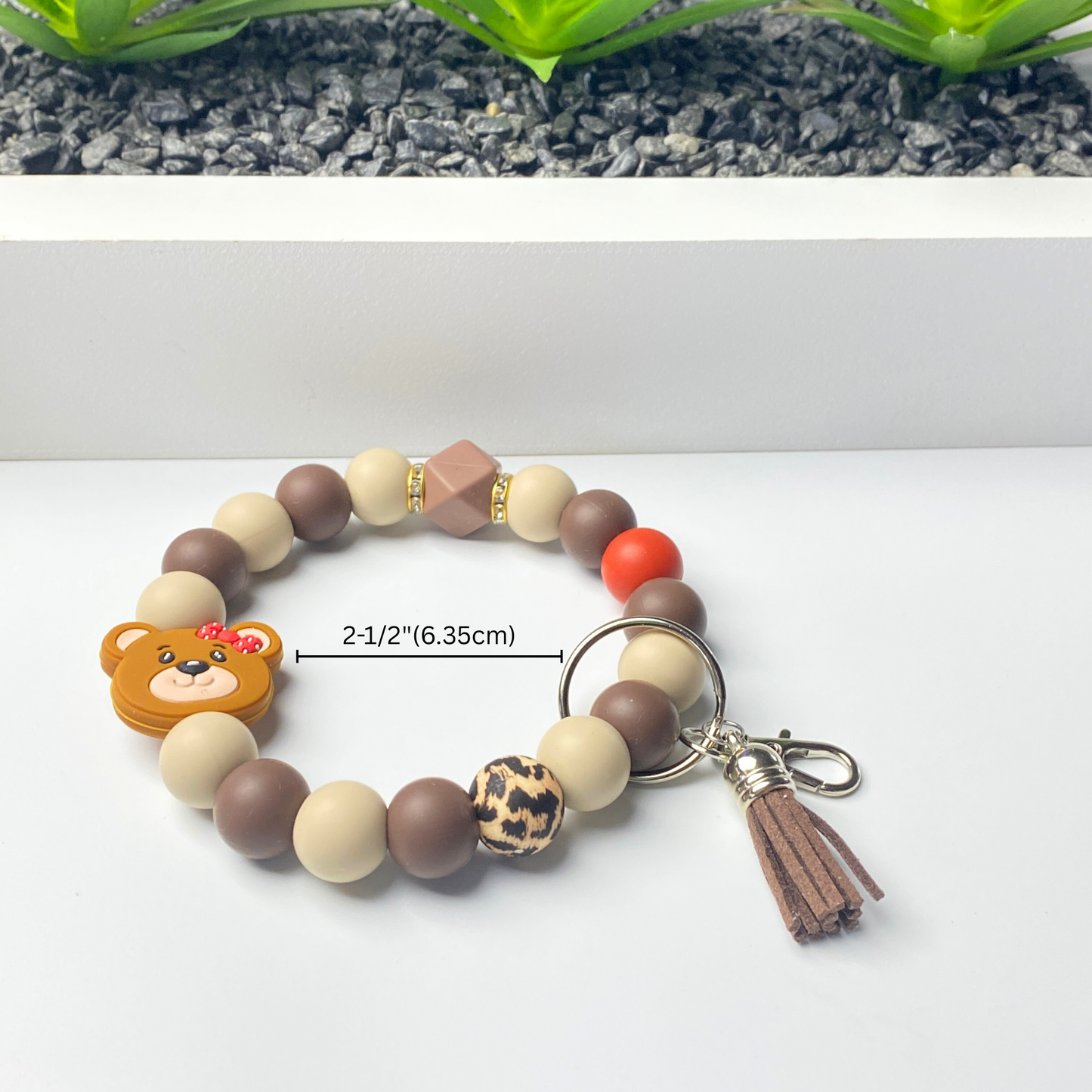 Bracelet with teddy bear charm and keychain on a white background