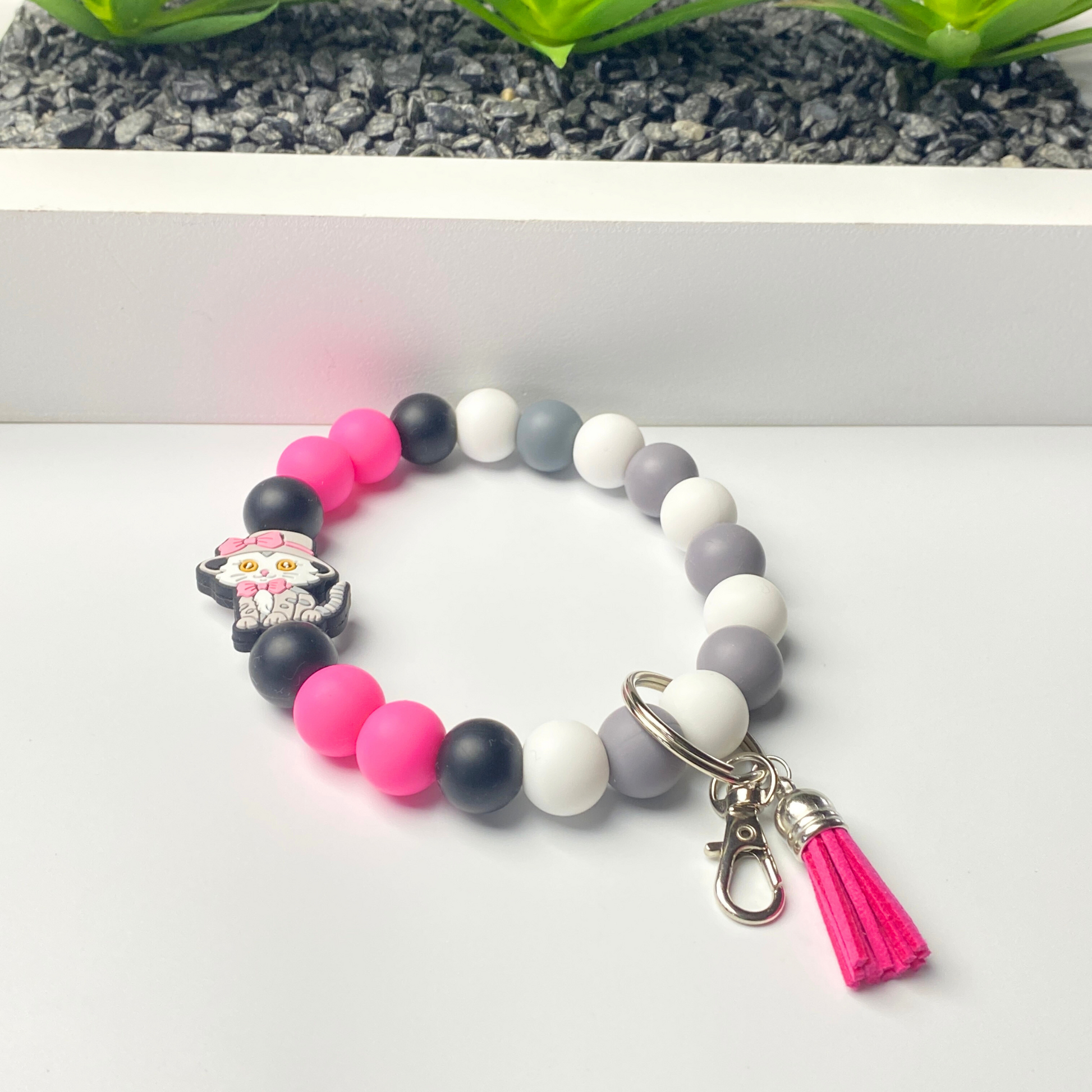 Colorful beaded bracelet with a keychain and tassel on a white background