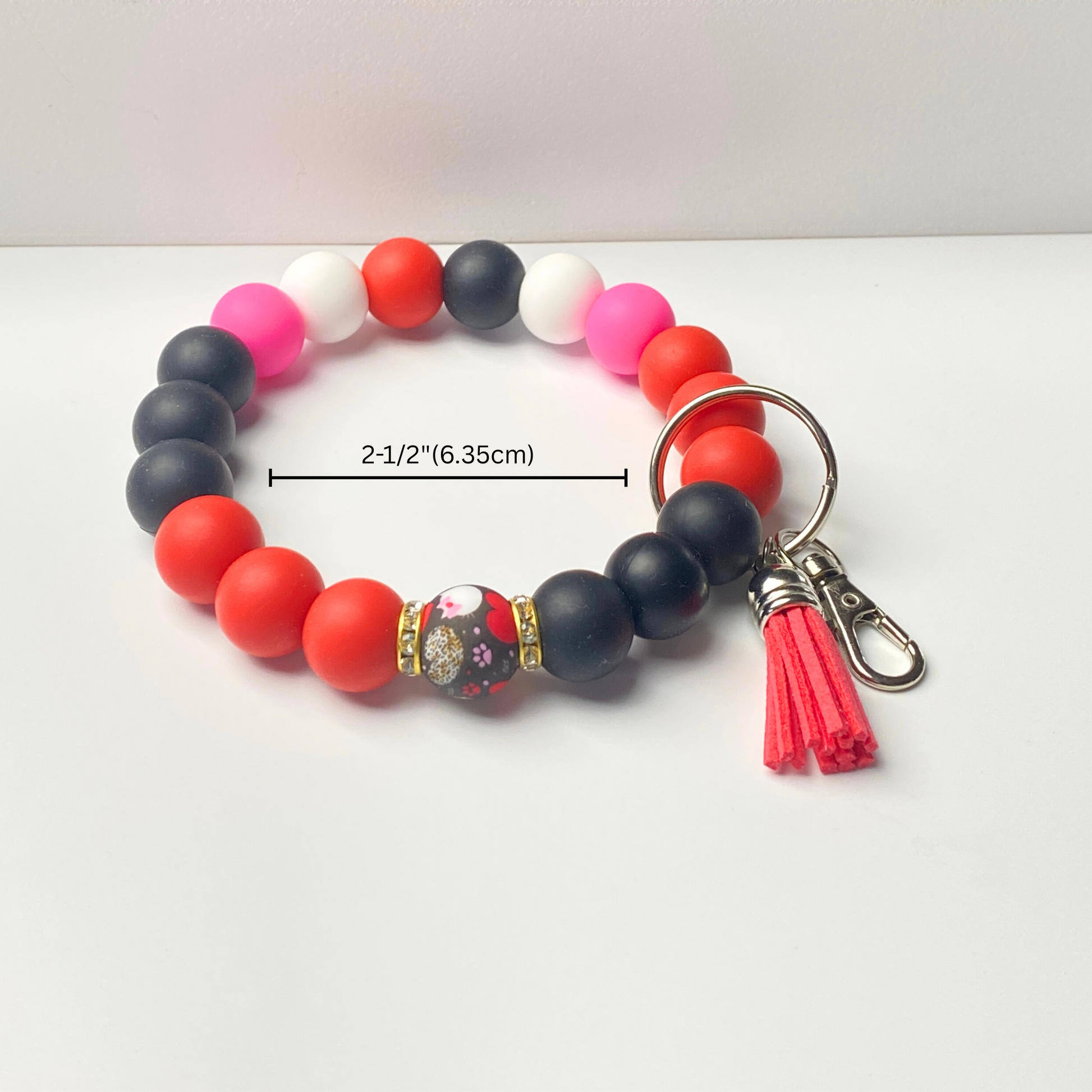 Beaded keychain with colorful beads and a tassel on a white background