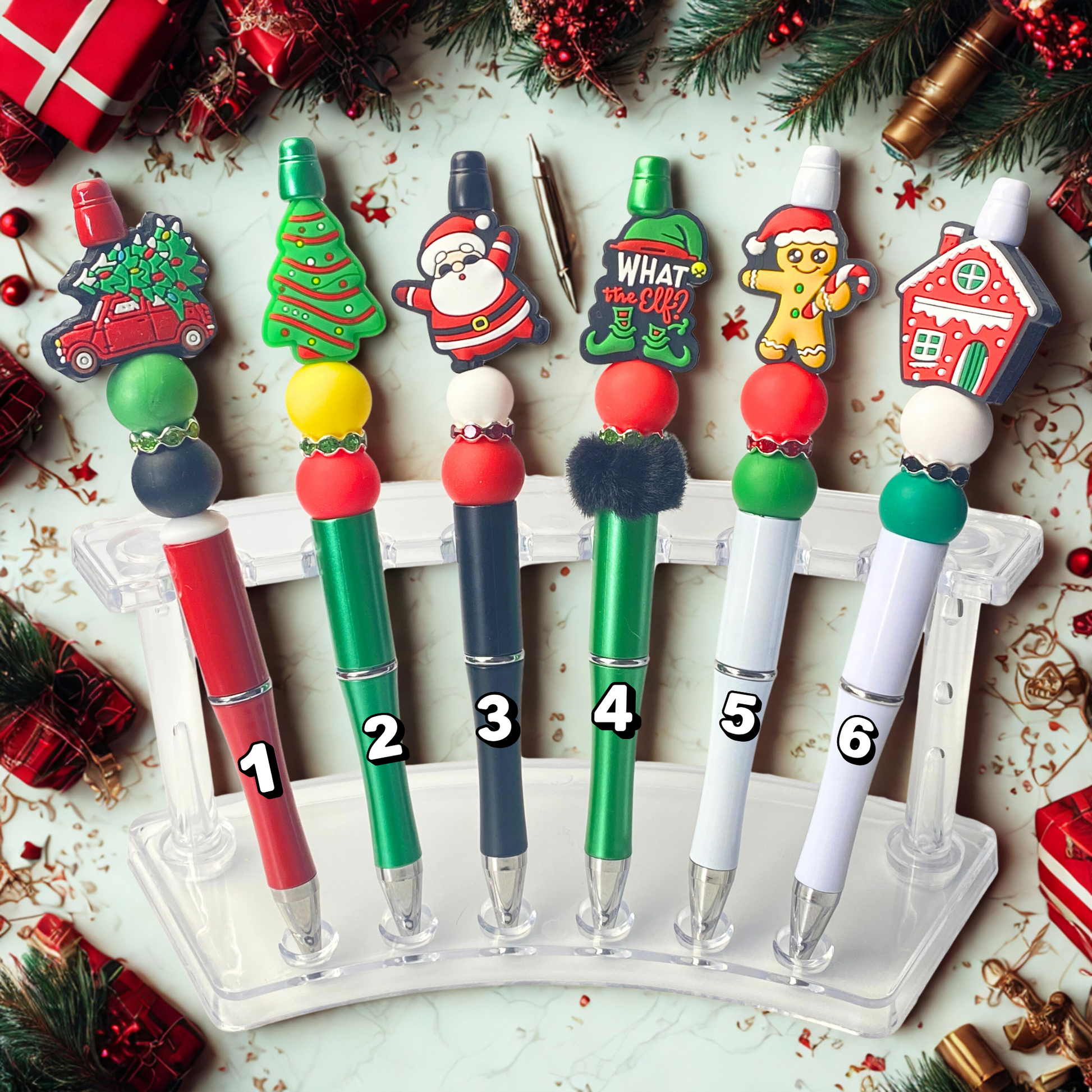 Set of Christmas-themed pens with decorative toppers on a festive background.