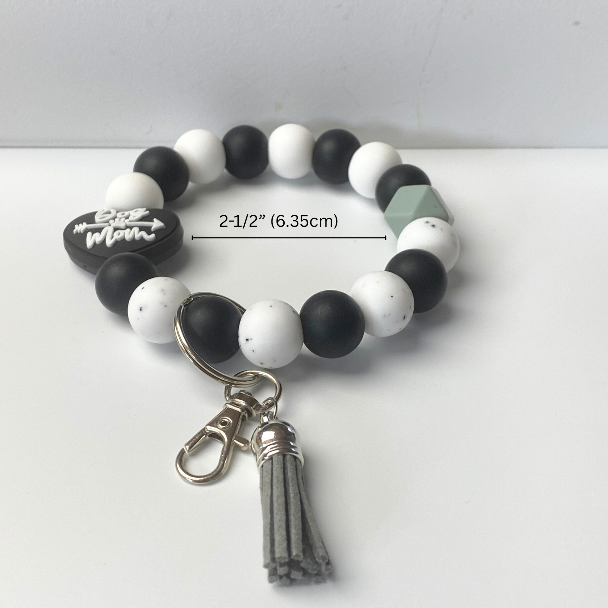 Black and white beaded bracelet with a tassel on a white background