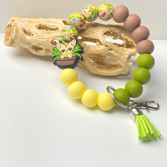 Colorful beaded keychain with a small figurine on a white background