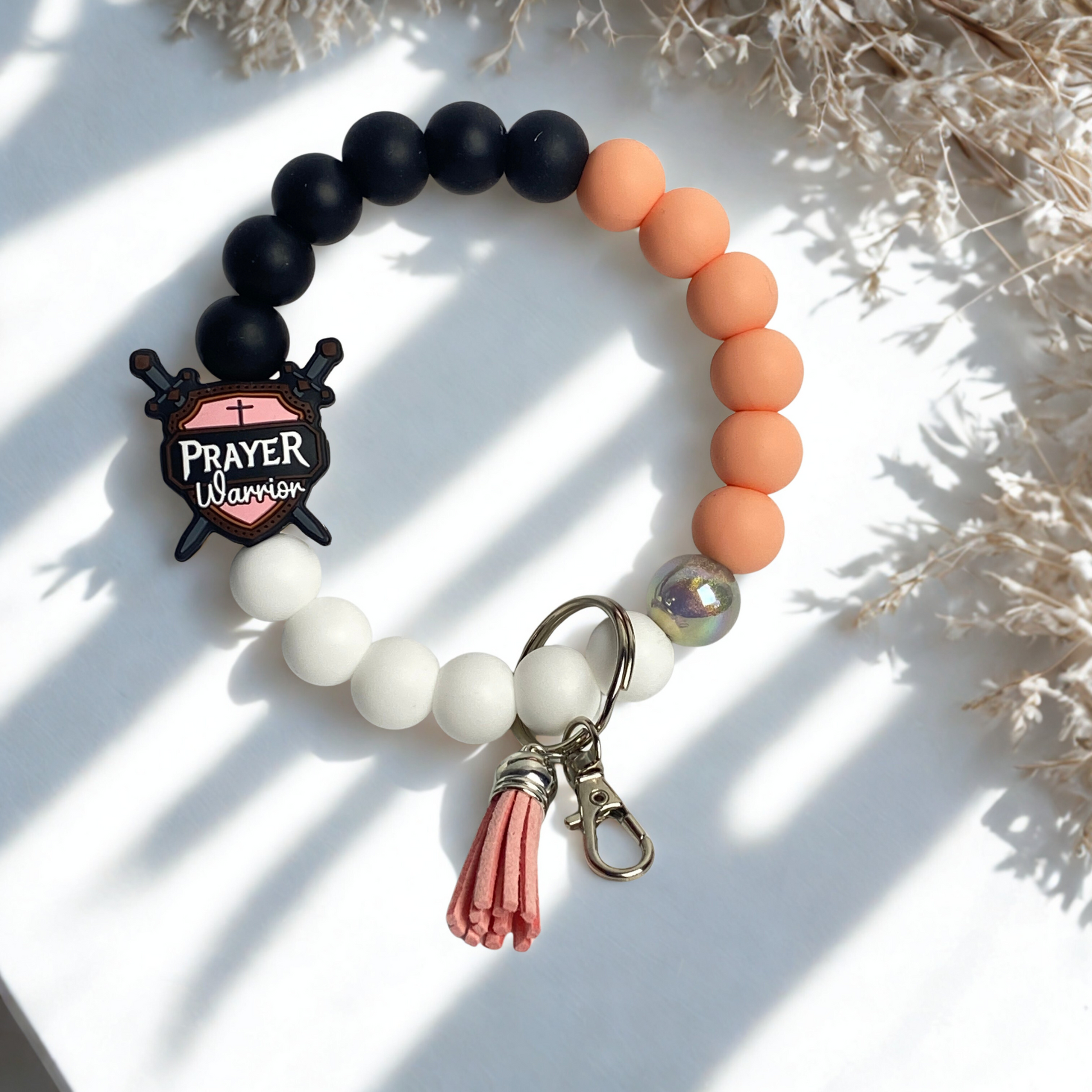 Beaded bracelet with 'Prayer Warrior' charm on a white background