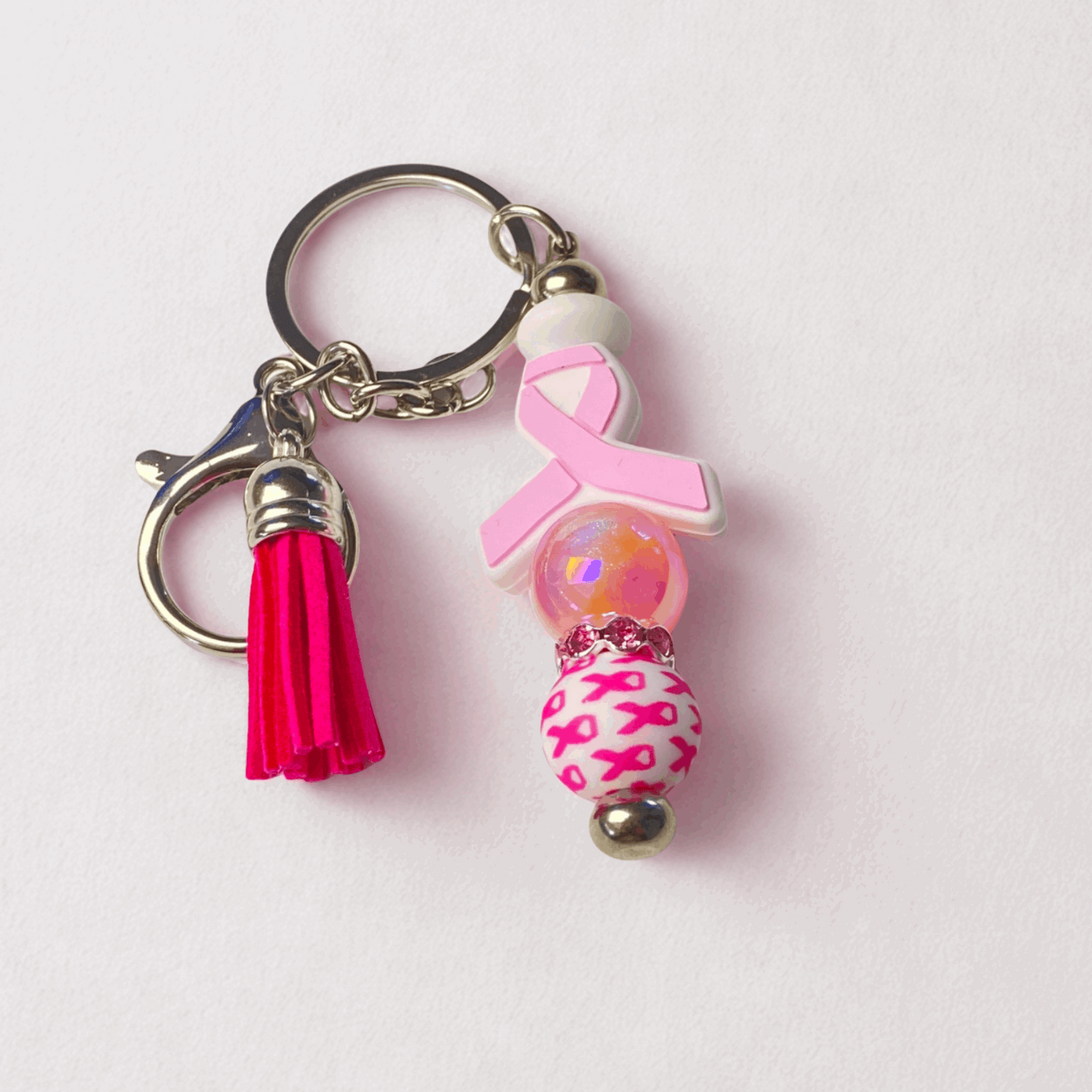 Keychain with pink ribbon and tassel on a light pink background