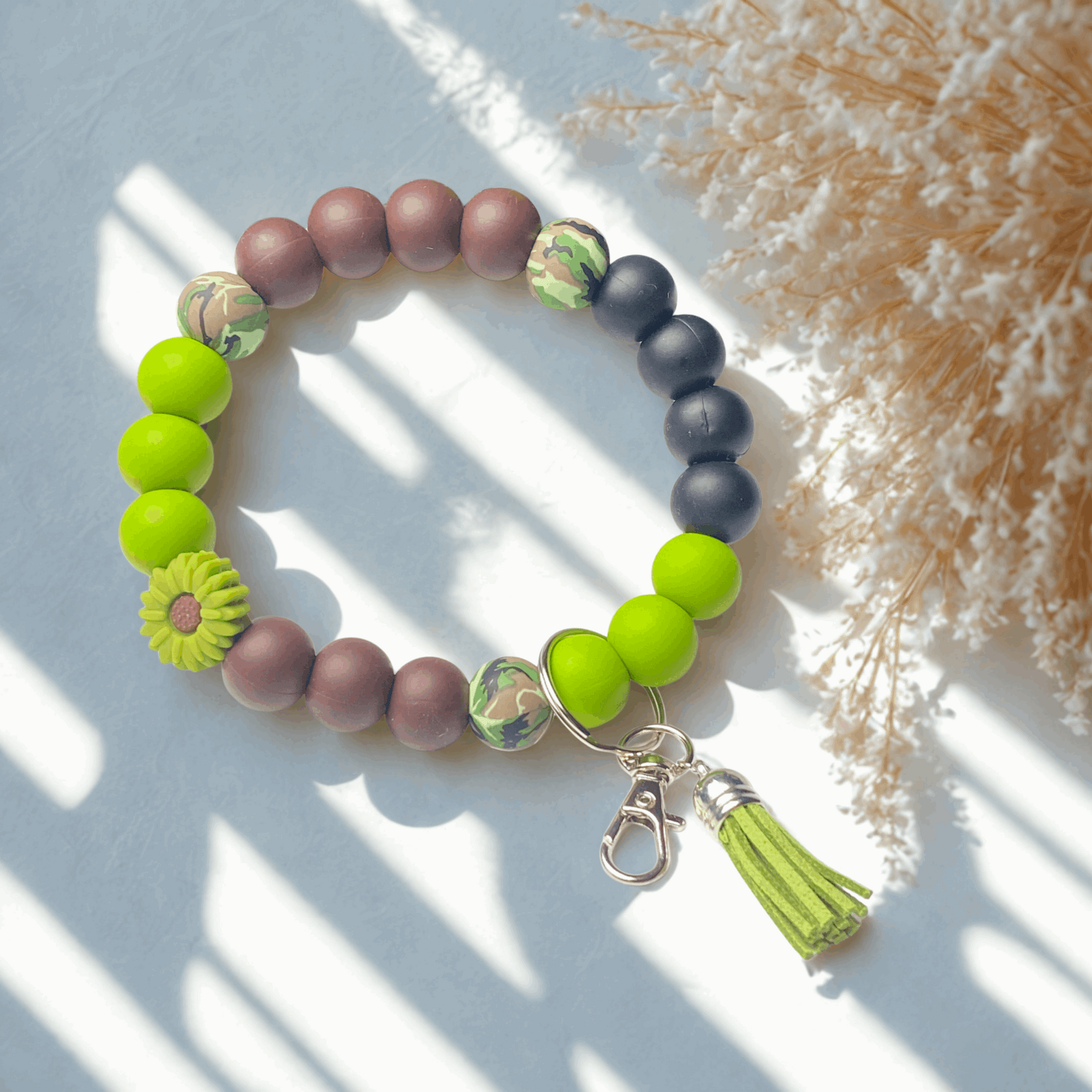Colorful beaded bracelet with a tassel on a light background