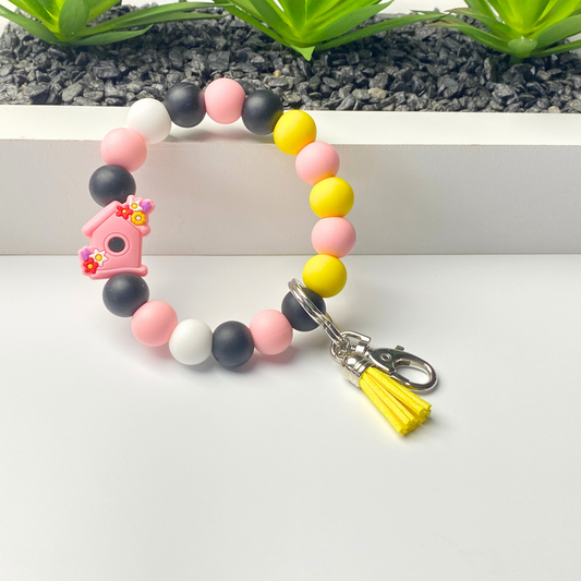 Colorful beaded bracelet with a keychain charm on a white background