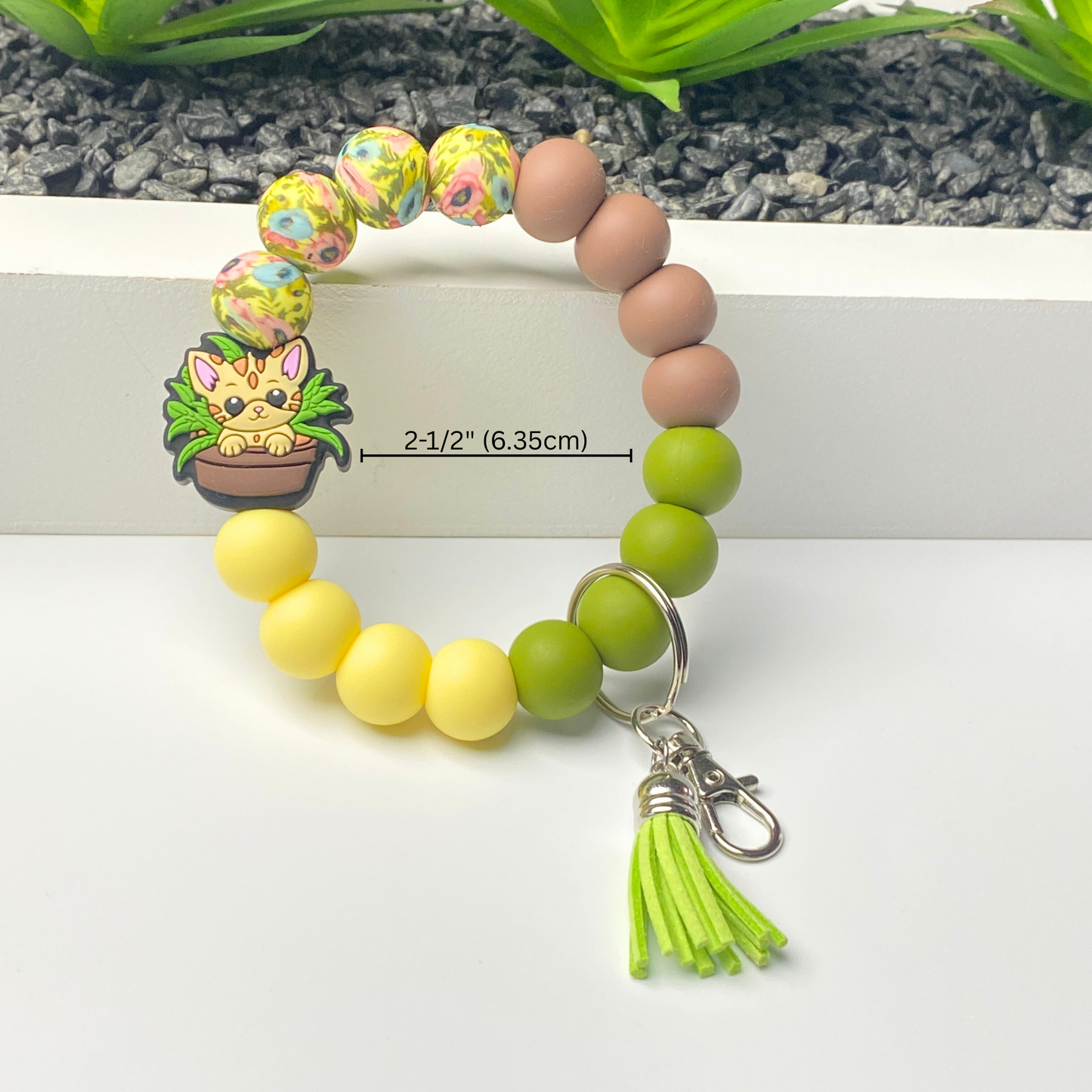 Colorful beaded bracelet with a keychain and tassel on a white background