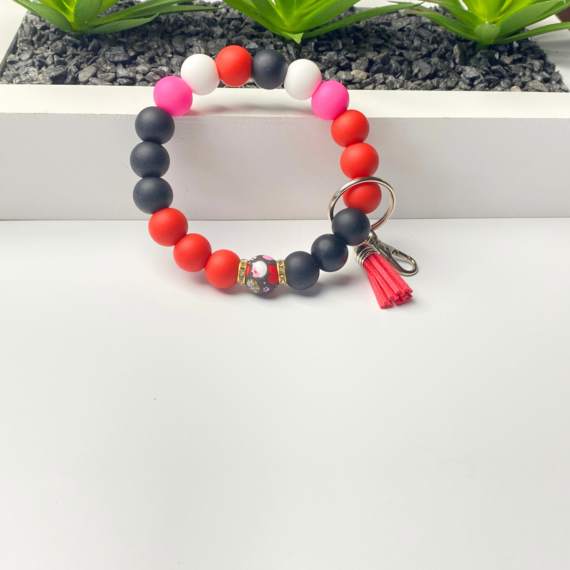 Colorful beaded keychain with tassel on a white surface