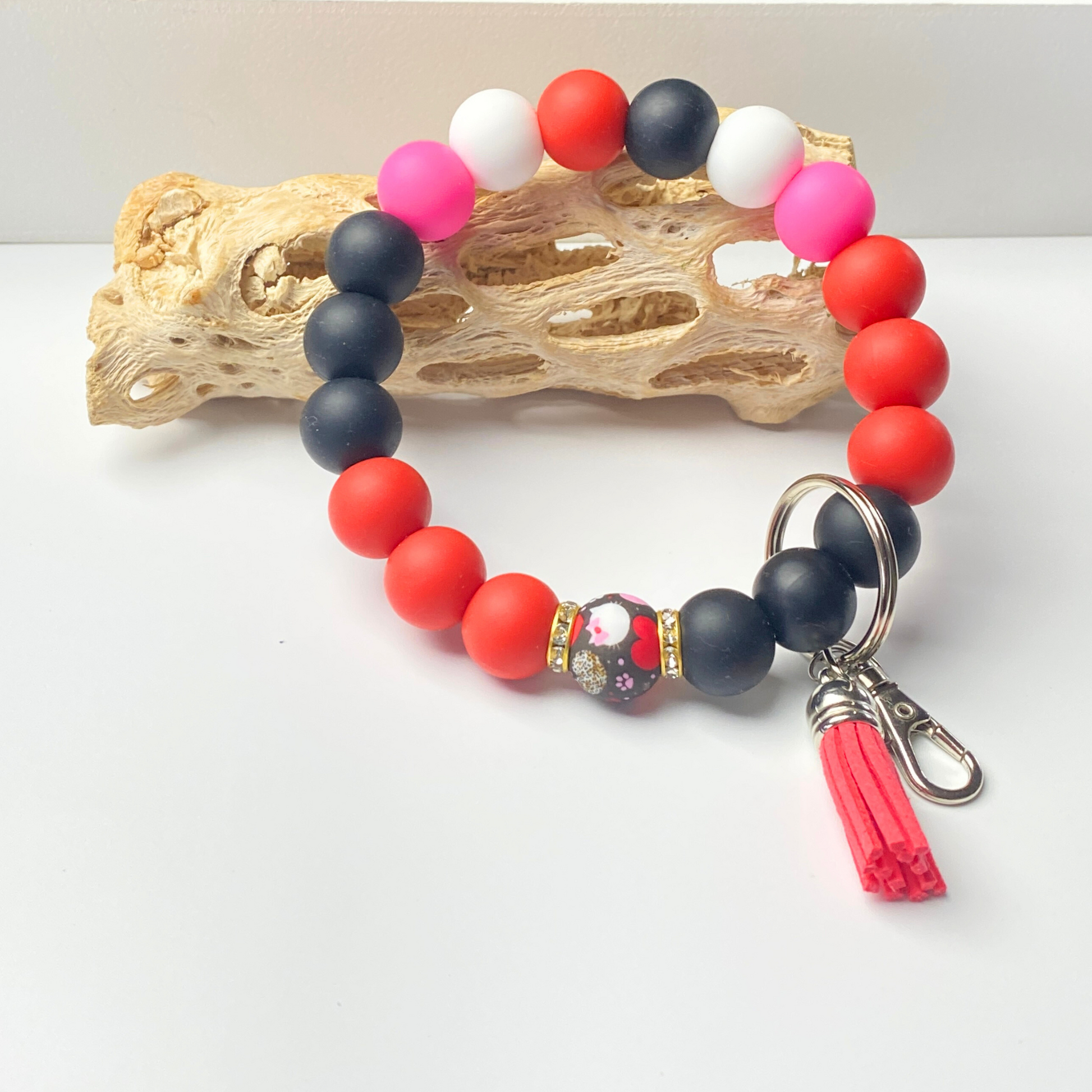Beaded bracelet with red, navy, and pink beads on a white background