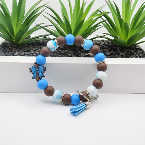 Beaded bracelet with blue, brown, and white beads on a white background with plants in the background