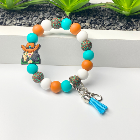 Colorful beaded keychain with a cowboy charm on a white surface