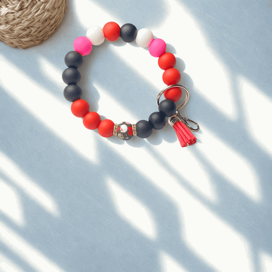 Colorful beaded keychain with tassel on a light blue surface