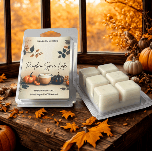 Packaged pumpkin spice latte wax melts on a wooden surface with autumn decorations.