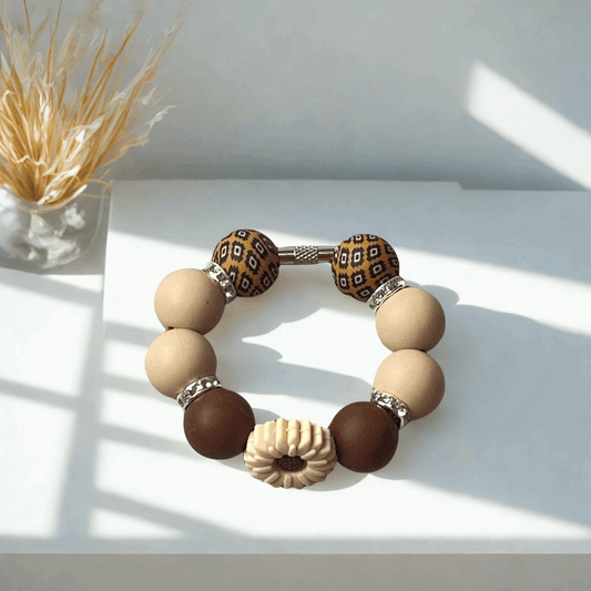 Beaded bracelet with brown and beige beads on a white surface
