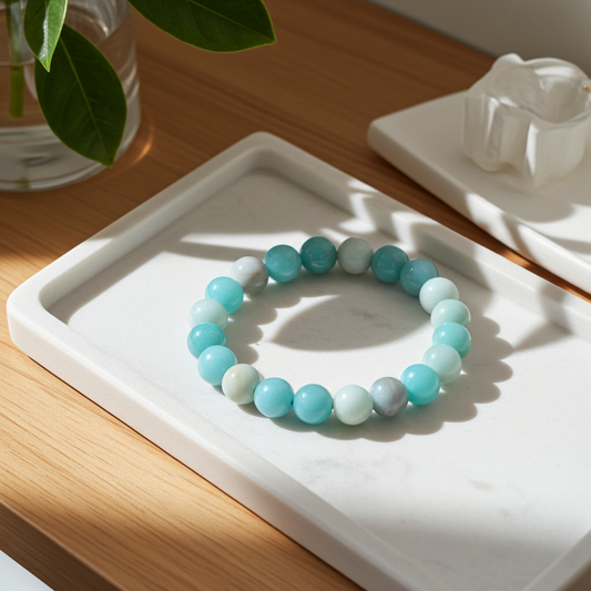 Turquoise beaded bracelet on a white tray with a wooden surface and plant in the background