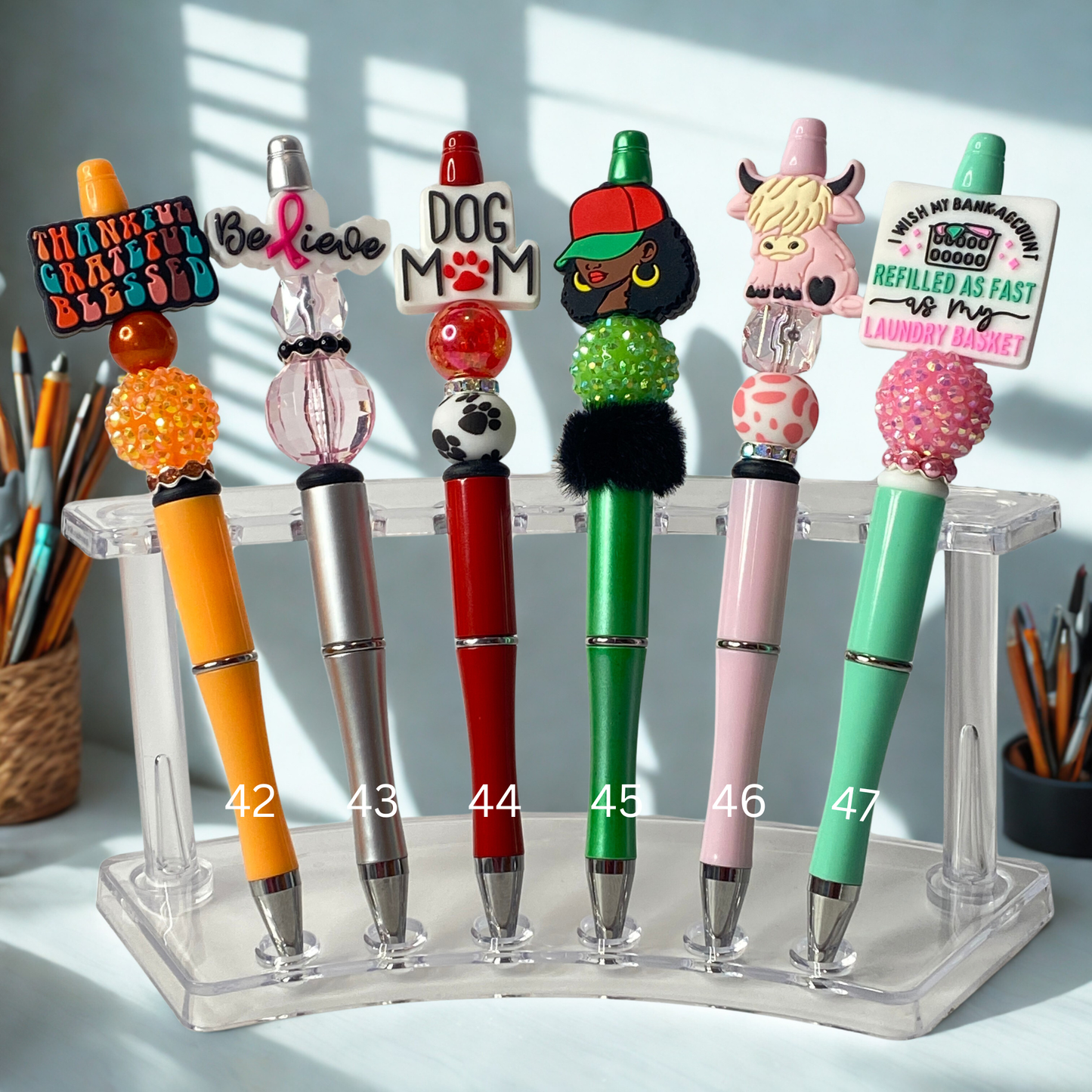 Colorful pens with unique designs on a stand against a light background