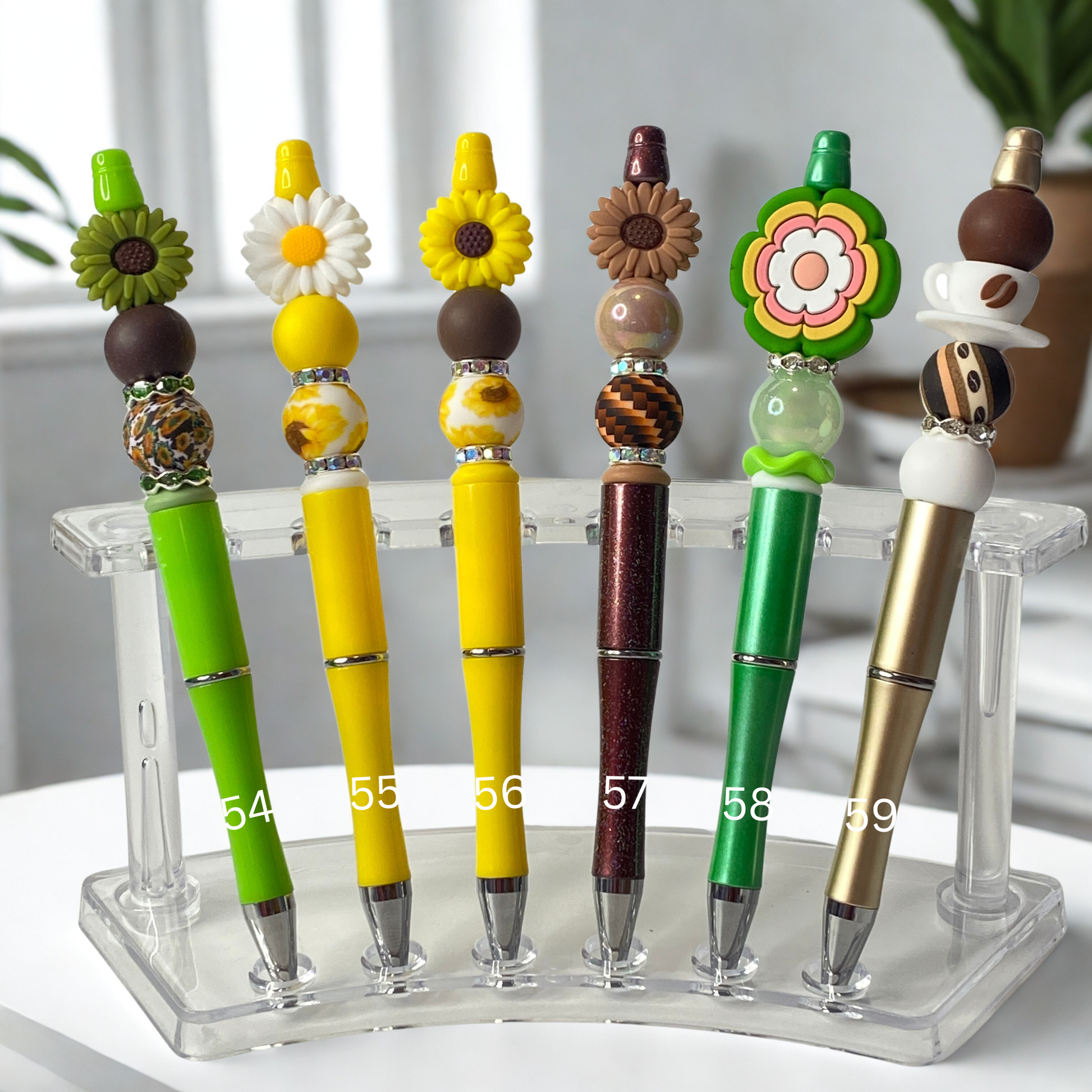 Colorful pens with decorative tops on a clear stand