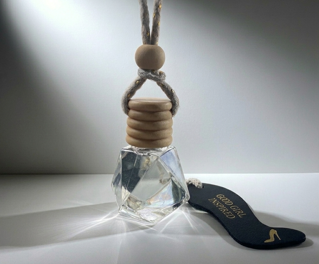 Small glass bottle with wooden cap hanging by a string on a white surface.
