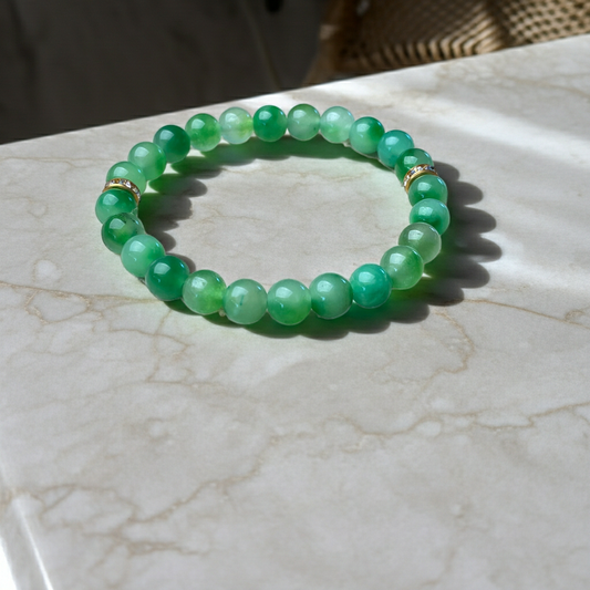 Green beaded bracelet on a marble surface