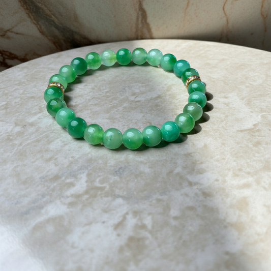 Green beaded bracelet on a marble surface