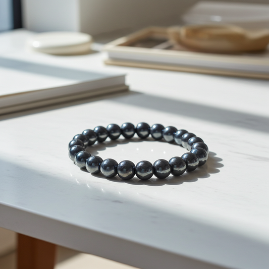 Black beaded bracelet on a white surface with a blurred background