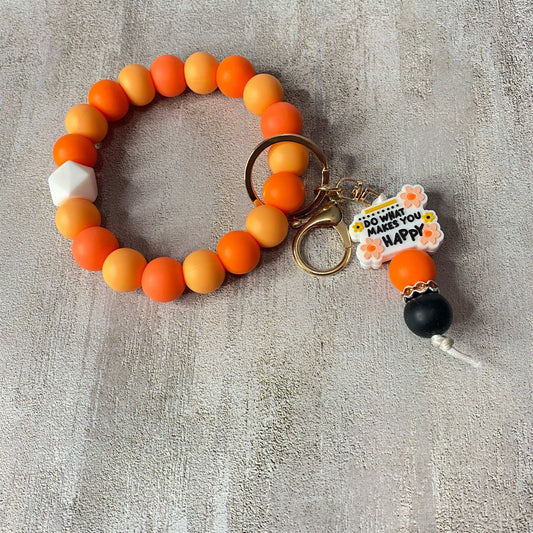 Beaded keychain with colorful beads on a textured gray surface