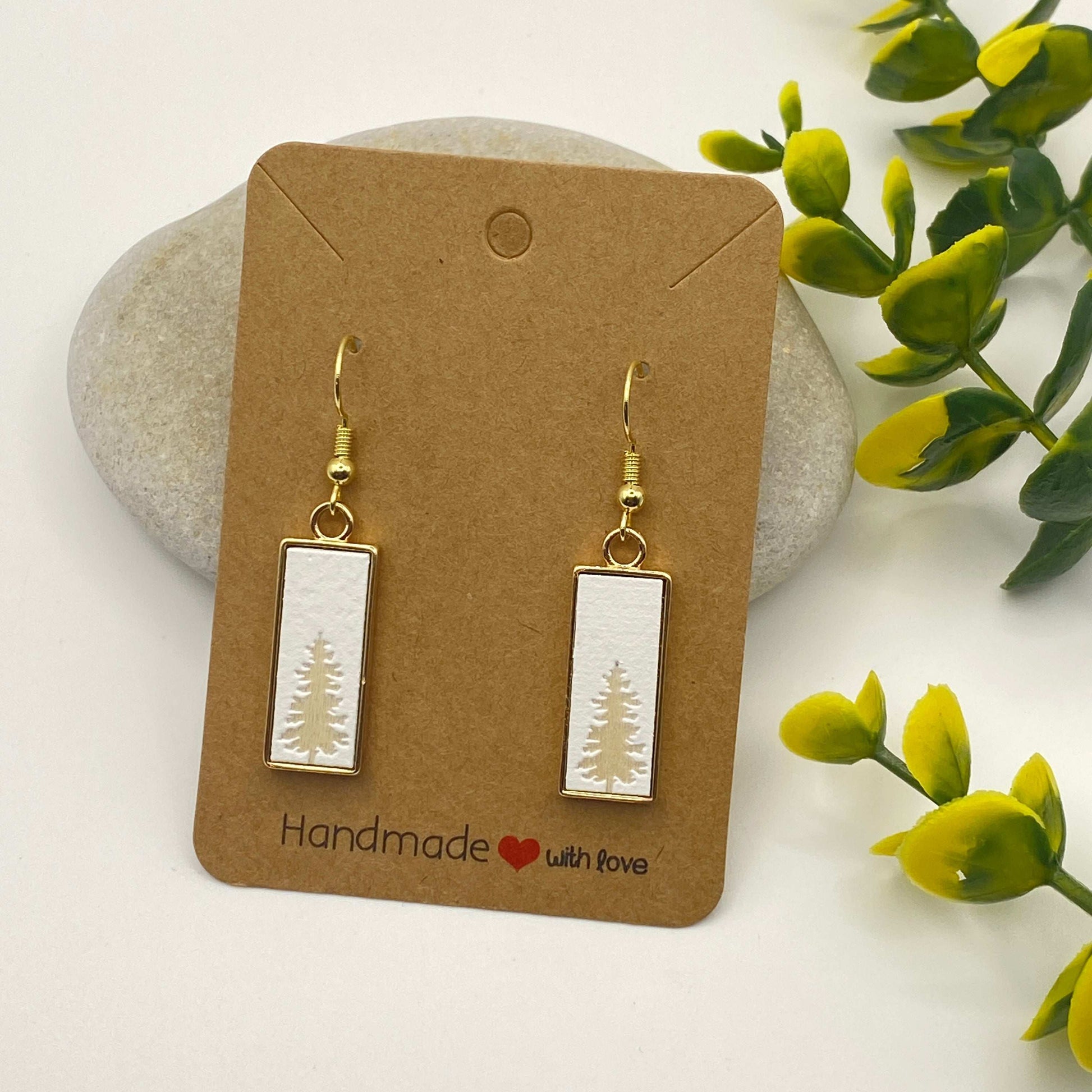 Pair of earrings on a 'Handmade with Love' card with green leaves in the background