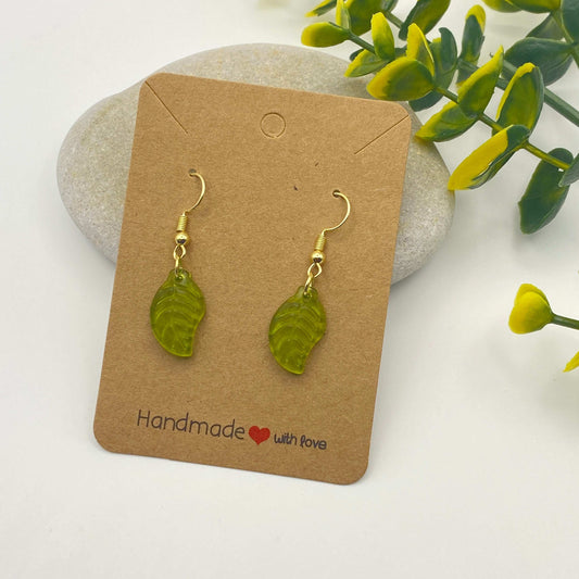 Green leaf-shaped earrings on a 'Handmade with Love' card with a natural background.